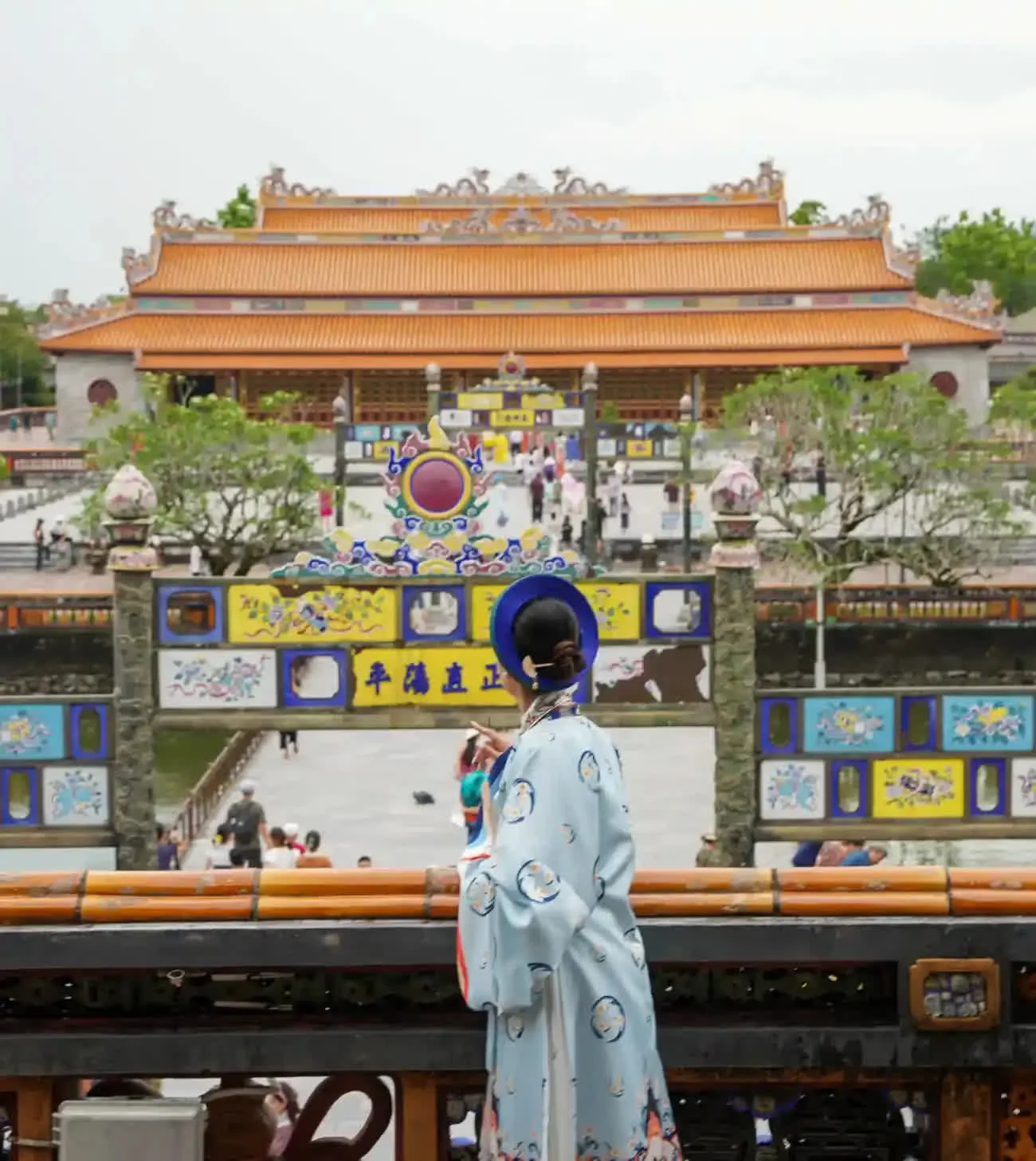 A guest in traditional áo dài overlooking the Imperial City in Huế